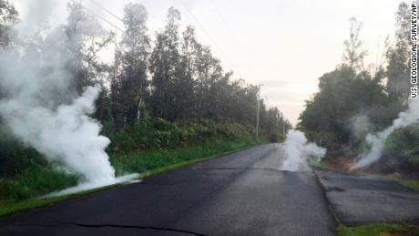 In this image released by the U.S. Geological Survey, steam rises from cracks in the road shortly before a fissure opened up on Kaupili Street in the Leilani Estates subdivision, Friday, May 4, 2018, in Pahoa, Hawaii. The Kilauea volcano sent more lava into Hawaii communities Friday, a day after forcing more than 1,500 people to flee from their mountainside homes, and authorities detected high levels of sulfur gas that could threaten the elderly and people with breathing problems.
 (U.S. Geological Survey via AP)