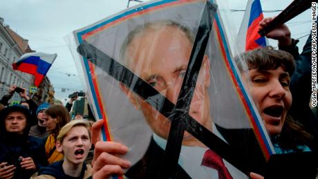 Protesters hold placards of Russian President Vladimir Putin during Saturday's rally.