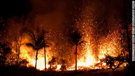 Lava errupts from a fissure on a residential street after the eruption of Kilauea.