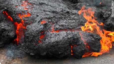 Lava brucia attraverso una strada Sabato nella comunità Leilani Estates su Hawaiiapos;s Big Island.