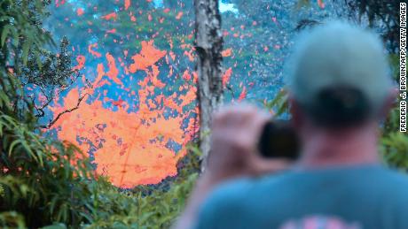 A man watches as lava spews from a fissure in the Leilani Estates subdivision near Pahoa, Hawaii.