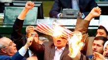 Iranian lawmakers burn two pieces of papers representing the U.S. flag and the nuclear deal as they chant slogans against the U.S. at the parliament in Tehran, Iran, Wednesday, May 9, 2018. Iranian lawmakers have set a paper U.S. flag ablaze at parliament after President Donald Trump's nuclear deal pullout, shouting, "Death to America!". President Donald Trump withdrew the U.S. from the deal on Tuesday and restored harsh sanctions against Iran. (AP Photo)