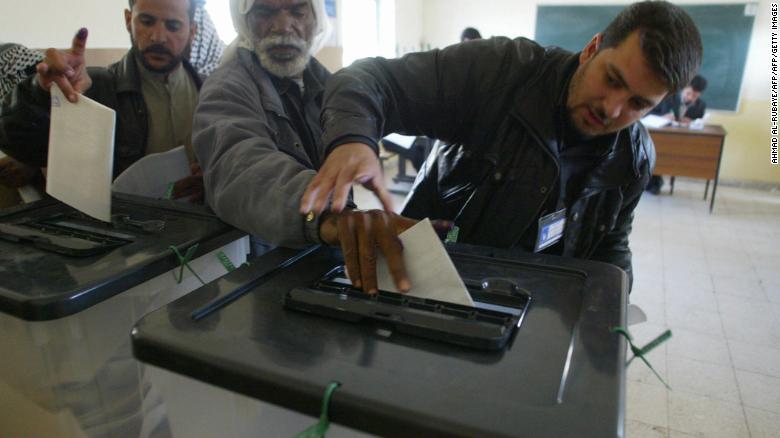 An official guides the hand of blind man Jawwad Shkeir, 56, as he cast his vote on 30 January 2005, in the southern holy city of Najaf. The elections were Iraq&#39;s first full vote since Saddam Hussein was routed from power in 2003.