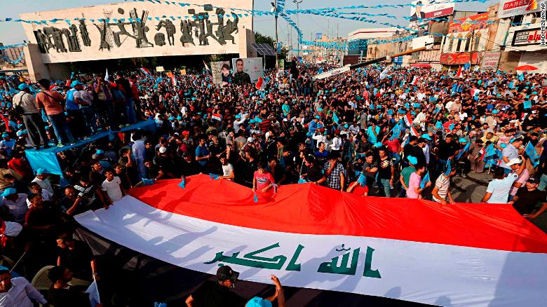 Followers of Shiite cleric Muqtada al-Sadr carry a huge Iraqi flag as they take part in a campaign rally in Baghdad on May 4.