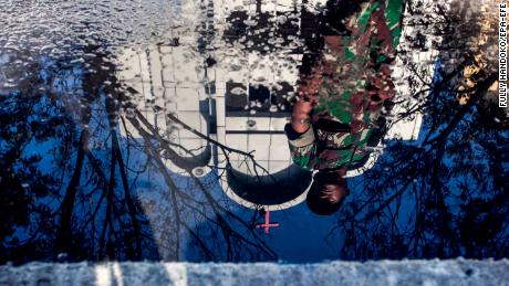 epaselect epa06734793 A reflection of an Indonesian soldier stands guard outside one of the churches that was hit by the bomb blast in Surabaya, East Java, East Java, Indonesia, 14 May 2018. According to media reports, at least four officers and six civilians were injured after an explosion following the deadly suicide bomb blasts that occurred at three churches that killed 13 in Surabaya.  EPA-EFE/FULLY HANDOKO