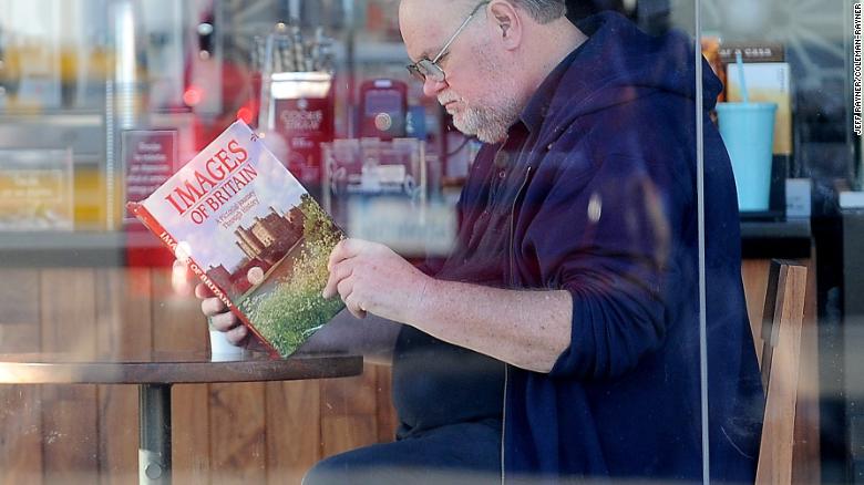 Meghan Markle's father Thomas Markle reads a book about Britain in an allegedly staged photo. 