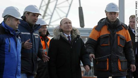 Russian President Vladimir Putin (C) inspects the road section of the road-and-rail Crimean Bridge over the Kerch Strait on March 14, 2018. / AFP PHOTO / POOL / YURI KOCHETKOV        (Photo credit should read YURI KOCHETKOV/AFP/Getty Images)