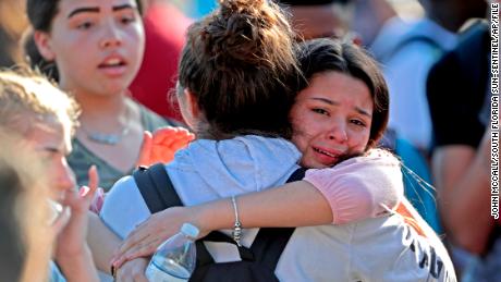 Students embrace after a February 14 shooting at Marjory Stoneman Douglas High School in Parkland, Florida.