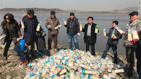 Activists in South Korea pose with bottled care packs for the North near the DMZ