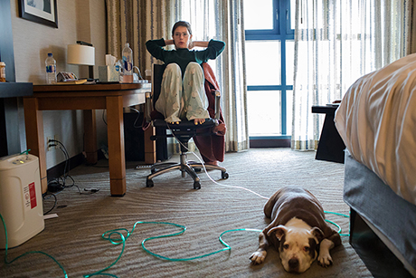 Claire Wineland sits in her hotel room with dog Daisy before heading to evaluations at the Center for Transplantation at UC San Diego Health.