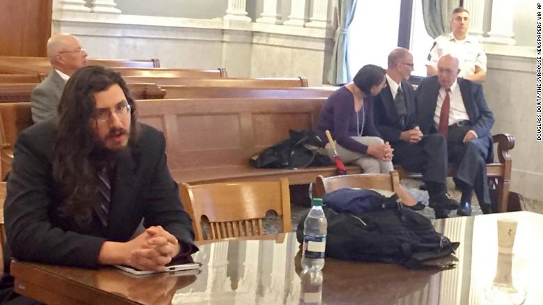 Michael Rotondo [left) at his eviction proceeding in Syracuse, New York. His parents, Mark and Christina, confer with their lawyer in the court gallery behind. 