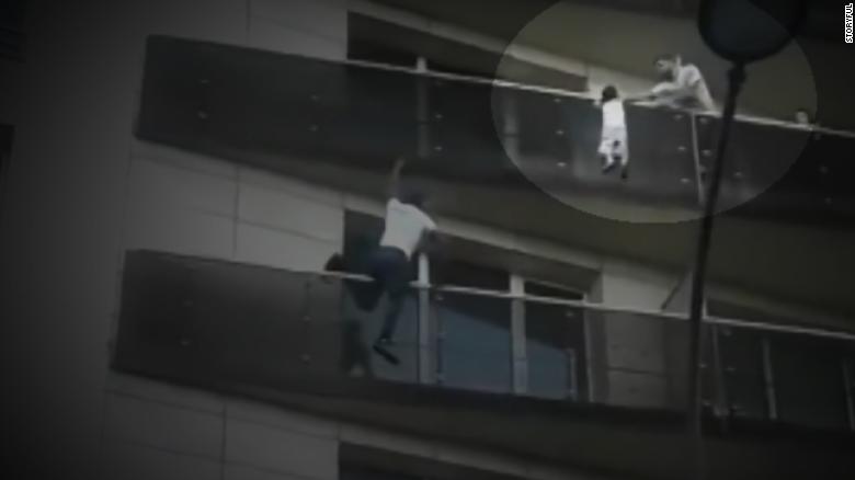 Moment man climbs building to save child