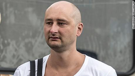 In this photo taken on Friday, May 31, 2013, Arkady Babchenko, 41, who had been scathingly critical of the Kremlin in recent years, stands at a police bus during an opposition rally in Moscow, Russia. Police in the capital of Ukraine say a Russian journalist has been shot and killed at his Kiev apartment. Ukrainian police said Arkady Babchenko&#39;s wife found him bleeding at the apartment on Tuesday, May 29, 2018 and called an ambulance, but Babchenko died on the way to a hospital. (AP Photo/Alexander Baroshin)