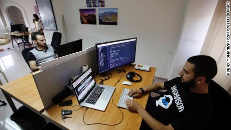 Palestinians work at the office of Red Crow, a startup that monitors security developments and sends real-time alerts and maps to clients, in Ramallah on August 17, 2016. 
It is one of a number of Palestinian start-ups in the occupied Palestinian territories, long overshadowed by neighbouring Israel's so-called "Start-up Nation".
The online platform automates and analyses nationwide real estate data to find investors the best property deals.
As in Silicon Valley, the staff dress casually, drink coffee from state-of-the-art machines in garish colours, and pad through the office wearing US-made headphones around their necks. / AFP / ABBAS MOMANI        (Photo credit should read ABBAS MOMANI/AFP/Getty Images)