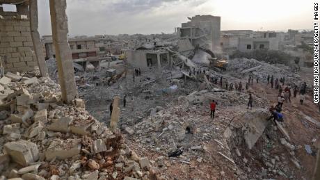 Syrians gather amid destruction in Zardana, Idlib province, in the aftermath of airstrikes Thursday.