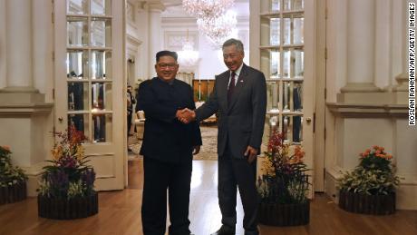 North Korea&#39;s leader Kim Jong Un (L) is welcomed by Singapore&#39;s Prime Minister Lee Hsien Loong (R) during his visit to The Istana, the official residence of the prime minister, following Kim&#39;s arrival in Singapore on June 10, 2018. - Kim Jong Un and Donald Trump will meet on June 12 for an unprecedented summit in an attempt to address the last festering legacy of the Cold War, with the US president calling it a &quot;one time shot&quot; at peace. (Photo by ROSLAN RAHMAN / AFP)     