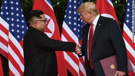 North Korea&#39;s leader Kim Jong Un (L) shakes hands with US President Donald Trump (R) after taking part in a signing ceremony at the end of their historic US-North Korea summit, at the Capella Hotel on Sentosa island in Singapore on June 12, 2018. 