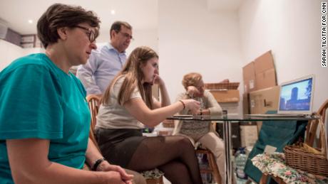 The Alves family, along with a former Grenfell neighbor, watch a documentary about the fire, in the kitchen of the their temporary home in Kensington.