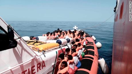 Migrants are transferred from the Aquarius to Italian Coast Guard vessels in the Mediterranean Sea.