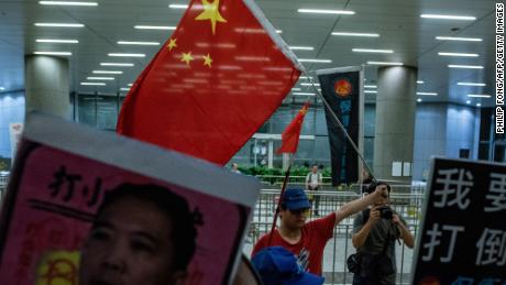 A Pro-Beijing protester (back centre) holds a Chinese flag during the anti-rail link rally outside the Legco complex in Hong Kong on June 14.