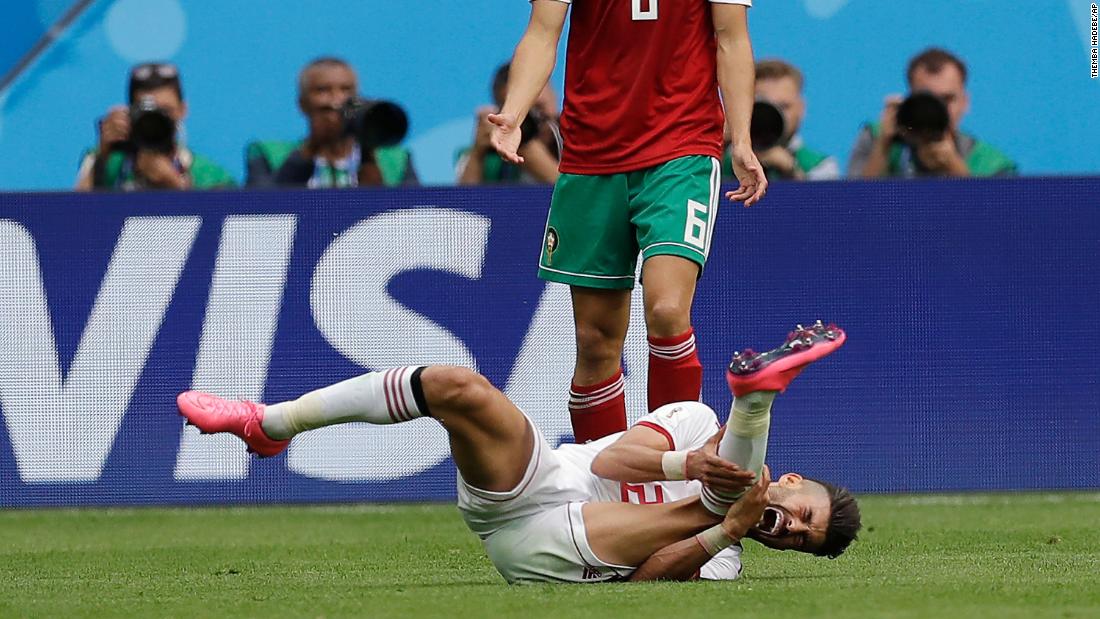 Iran&#39;s Alireza Jahanbakhsh grimaces in pain in front of Morocco&#39;s Romain Saiss.