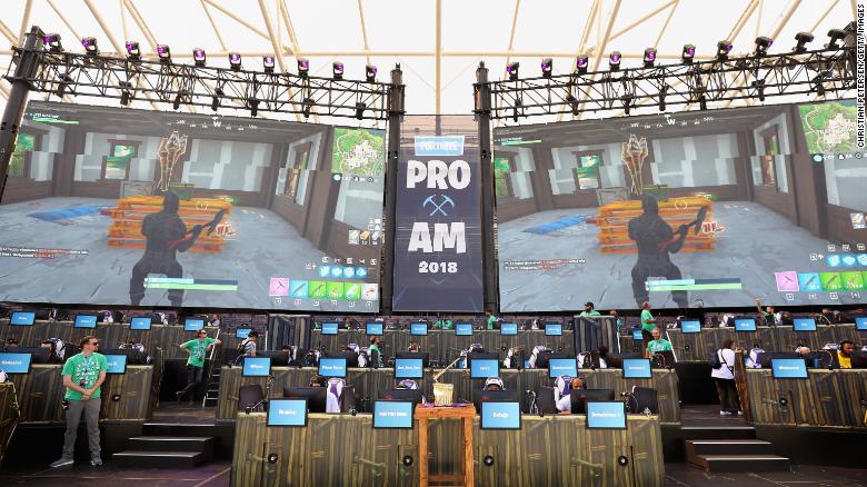 The Fortnite trophy is displayed in the foreground as gamers compete in Epic Games&#39; Fortnite E3 Tournament.