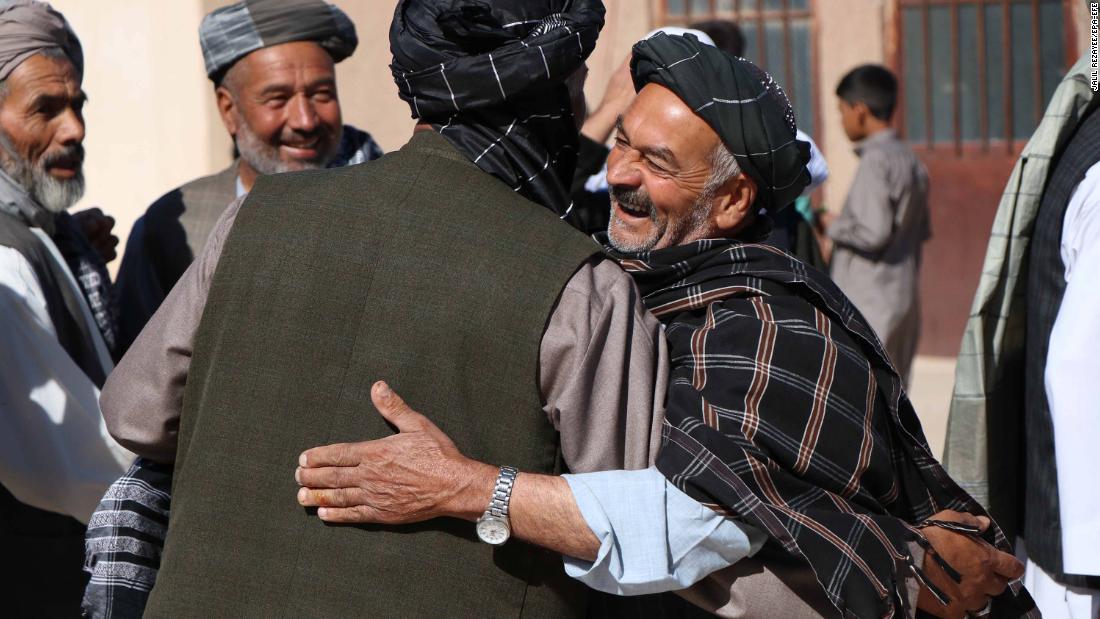 People greet each other after offering prayers in Herat, Afghanistan.