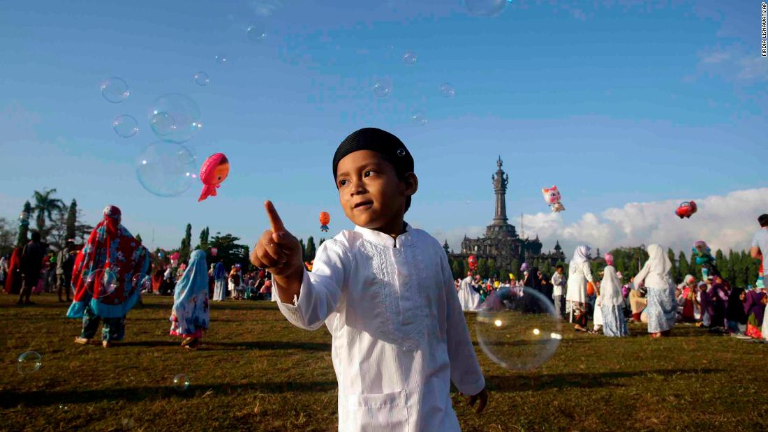 A boy plays with bubbles during Eid al-Fitr prayers in Bali, Indonesia.