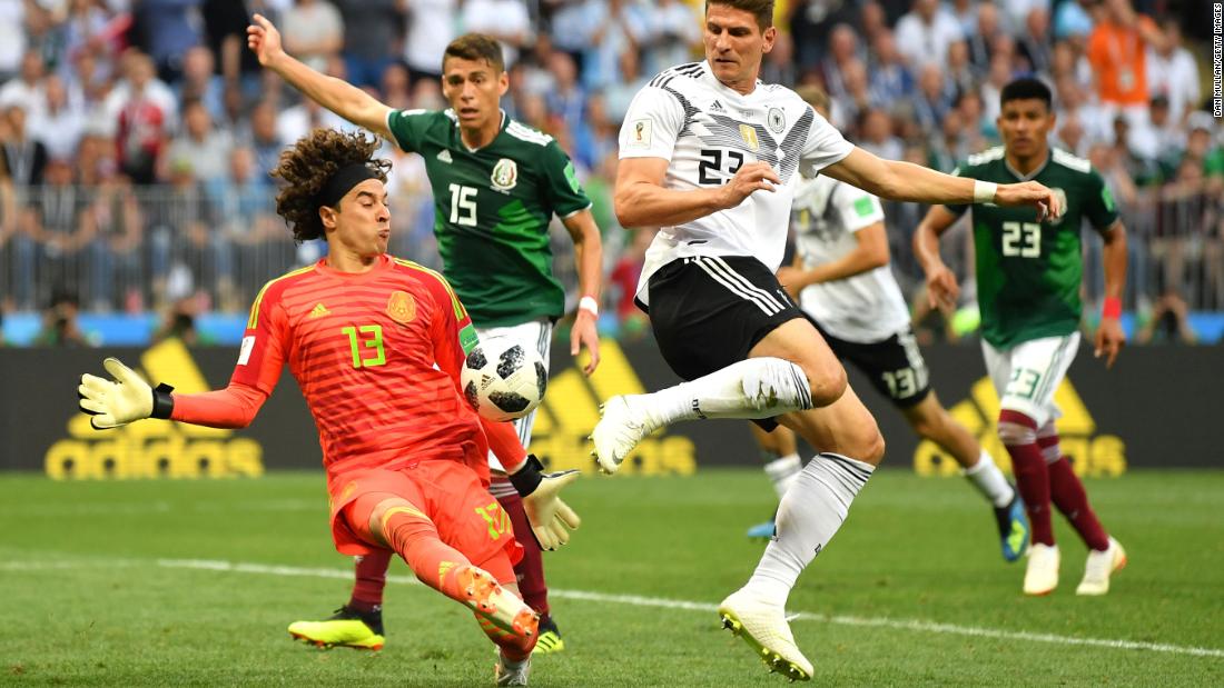 Mexican goalkeeper Guillermo Ochoa makes a late save against Mario Gomez.