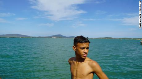 A Cuban boy swims in June 2018 in the sparkling blue waters of Guantanamo Bay from the town of Caimanera, Cuba. Residents of the town say the base bans their access to some of the area&#39;s best beaches and most pristine natural environments.