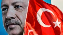 Turkish flags flutter nest to a huge portrait of Turkey's President and leader of the Justice and Development Party (AKP) Recep Tayyip Erdogan as he gives a speech during an AKP pre-election rally in Yenikapi Square in Istanbul on June 17, 2018. - With a week to go to crucial Turkish elections, the leader of the AKP  and his main rival of the secular Republican People's Party (CHP) are trading blows in an unexpectedly bruising fight to win control of the country. (Photo by Aris MESSINIS / AFP)        (Photo credit should read ARIS MESSINIS/AFP/Getty Images)