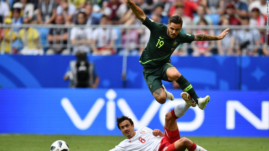 Australia&#39;s Joshua Risdon jumps over Thomas Delaney.