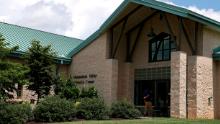 A person walks into the entrance of the Shenandoah Valley Juvenile Center on Wednesday, June 20, 2018 in Staunton, Va. Immigrant children as young as 14 housed at the juvenile detention center say they were beaten while handcuffed and locked up for long periods in solitary confinement, left nude and shivering in concrete cells. The abuse claims are detailed in federal court filings that include a half-dozen sworn statements from Latino teens jailed there for months or years. (AP Photo/Zachary Wajsgras)