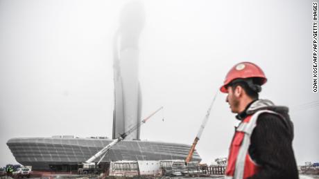 A worker looks at the control tower of a new airport under construction in Istanbul on April 13.