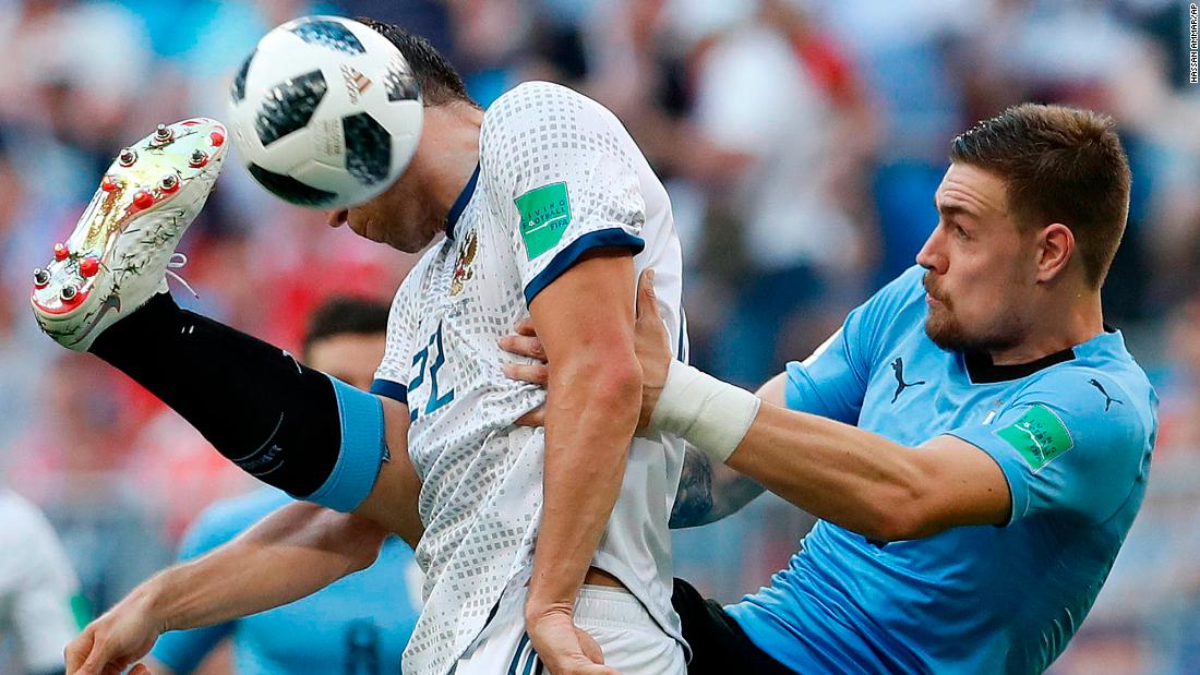 Russia&#39;s Artem Dzyuba, in white, competes with Uruguay&#39;s Sebastian Coates during Uruguay&#39;s 3-0 victory on June 25. Uruguay won all three of its matches in the group stage. This was Russia&#39;s first loss.