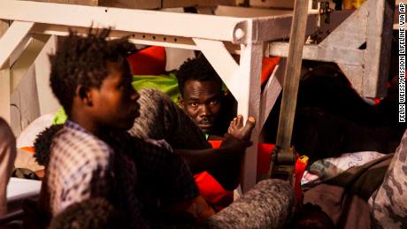Rescued migrants sit in the search and rescue ship Lifeline as the boat remained stranded Monday.