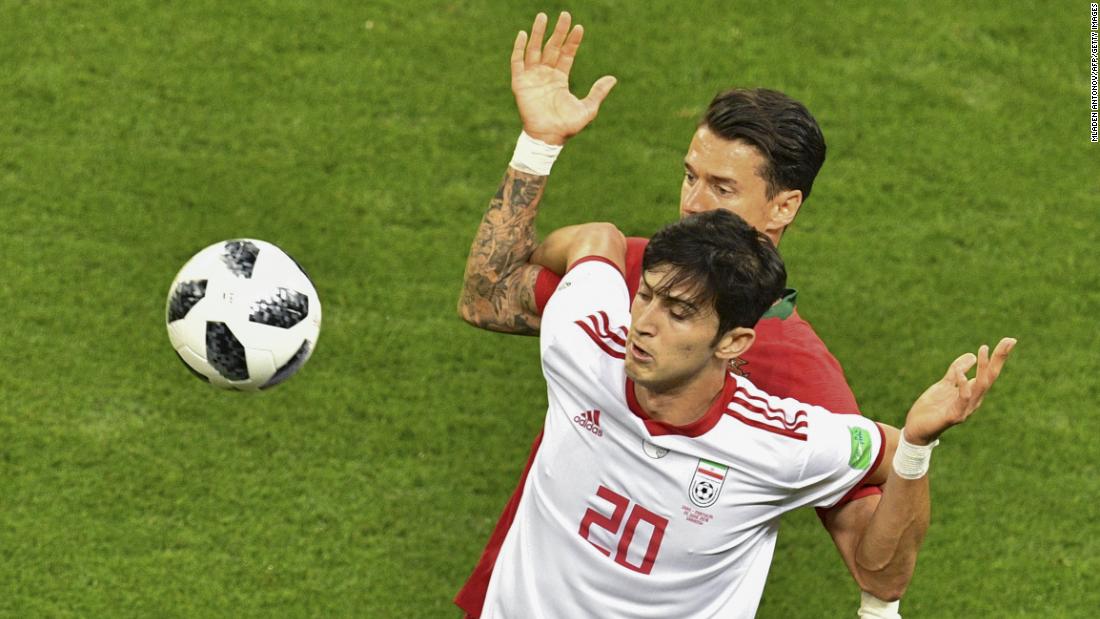 Iranian forward Sardar Azmoun shields the ball from Portuguese defender Jose Fonte.