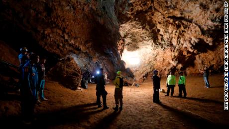 Rescue teams gather Monday in a deep cave where the group of boys went missing.