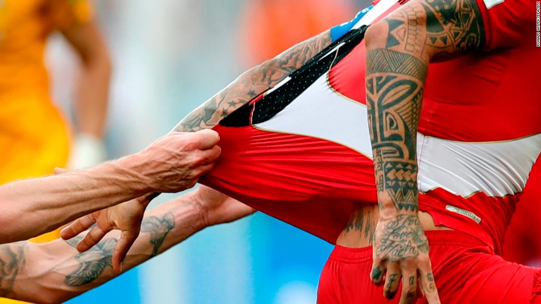 Aaron Mooy tugs on the jersey of Peru&#39;s Paolo Guerrero.