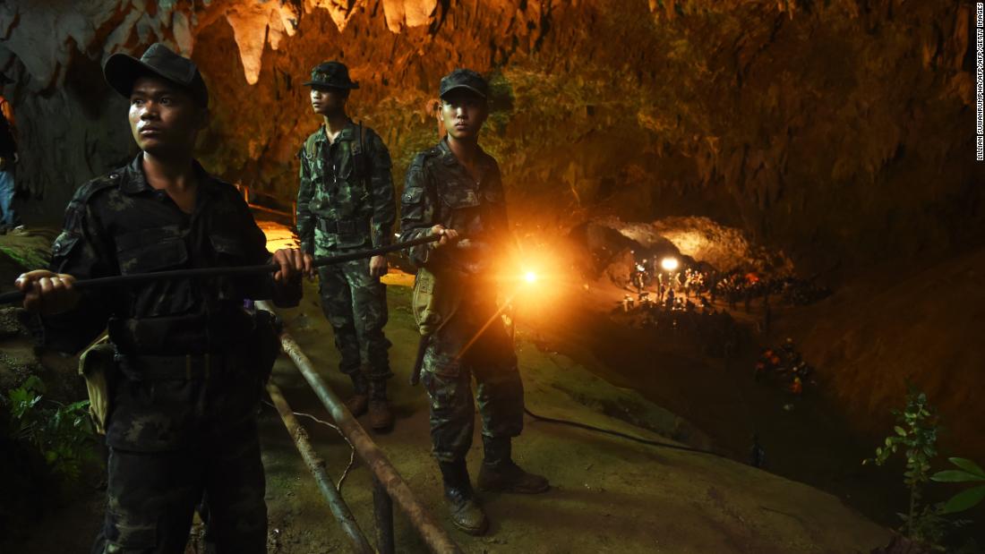 Thai soldiers relay electric cable deep into the entrance of the Tham Luang Nang Non cave network.