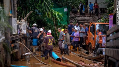 Rescue workers work on the water pumping machine at the entrance of the Tham Luang Nang Non cave network.