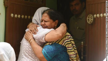 Relatives mourn outside the house, where 11 members of a family were found dead inside their home in the Indian capital of Delhi, on July 1, 2018.
