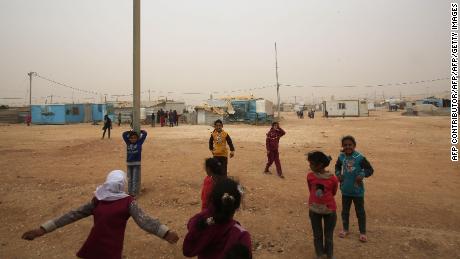 Syrian refugee children play during a sand storm at the Zaatari refugee camp on November 13, 2017. Some 80,000 Syrian refugees living in the Zaatari camp will have access to 14 hours of electricity per day instead of eight hours, thanks to the opening of the new solar power station. / AFP PHOTO / KHALIL MAZRAAWI (Photo credit should read KHALIL MAZRAAWI/AFP/Getty Images)