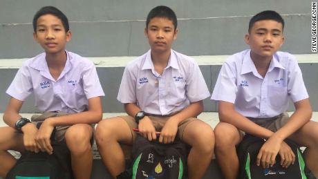 Kittichoke Konkaew (far left), Puwadet Kumngoen (far right),  and a friend await news of their classmate Nuttawut Takumsong.