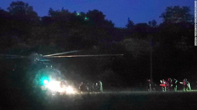 Emergency responders surround a helicopter prior to departing for the hospital on Sunday, July 8, after members of the soccer team had been rescued.