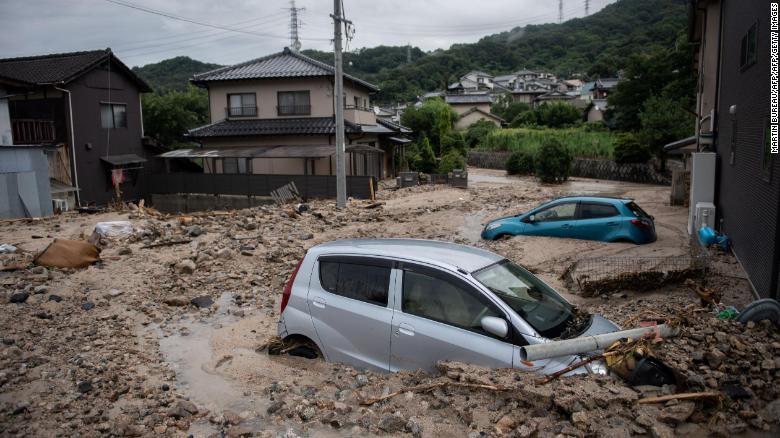 Cars trapped in the mud after floods in Saka, Hiroshima prefecture on July 8.