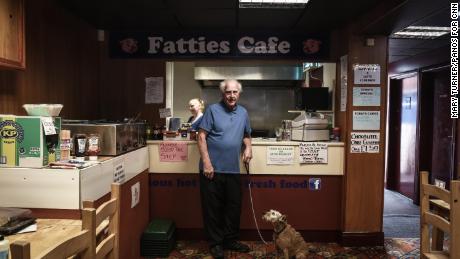 Matthew Allon and his dog Spike, pictured in Fatties Cafe, in the district of Concord in Washington, Sunderland on 9th July 2018. Pictured behind is Kelly Maughan who works in the cafe and has lived in Washington all her life. President Donald Tump is visiting the United Kingdom on Friday 13th July and is expected to be greeted with protests in London and around the country. Photograph by Mary Turner/ Panos Pictures
