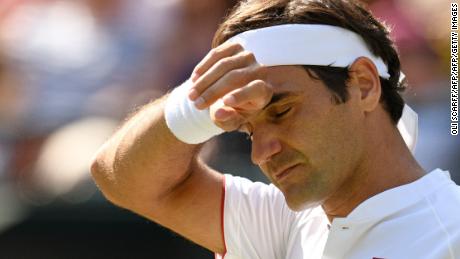 Roger Federer puts his hand to his brow.