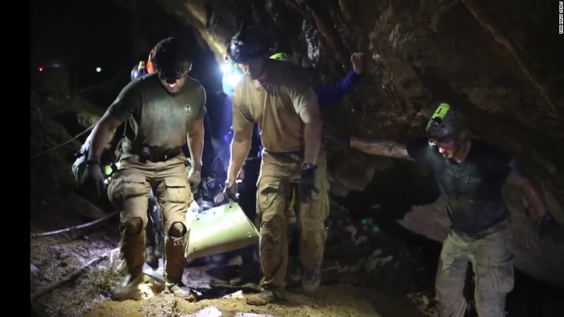 Rescuers carry one of the boys out of the cave.