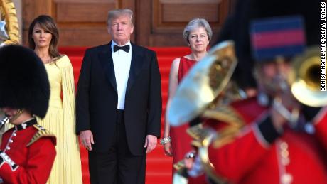 Britain&#39;s Prime Minister Theresa May (R) US President Donald Trump (C) and his wife US First Lady Melania Trump (L) stand on steps in the Great Court watching and listening to the bands of the Scots, Irish and Welsh Guards perform a ceremonial welcome as they arrive for a black-tie dinner with business leaders at Blenheim Palace, west of London, on July 12, 2018, on the first day of President Trump&#39;s visit to the UK. - The four-day trip, which will include talks with Prime Minister Theresa May, tea with Queen Elizabeth II and a private weekend in Scotland, is set to be greeted by a leftist-organised mass protest in London on Friday. (Photo by Ben STANSALL / POOL / AFP)        (Photo credit should read BEN STANSALL/AFP/Getty Images)